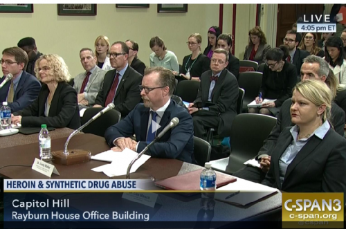 Briefing panelists at a table with audience 